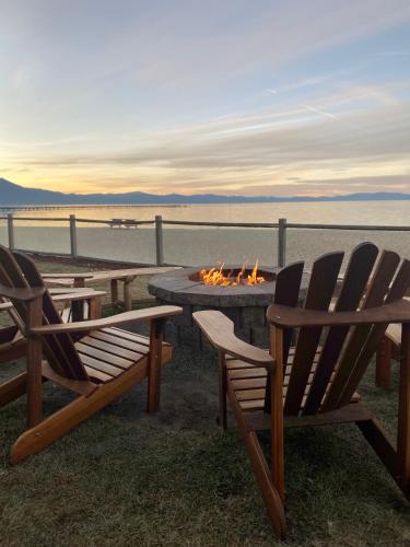 a fire pit with two chairs and a table with a fire burns at Tahoe Lakeshore Lodge & Spa in South Lake Tahoe