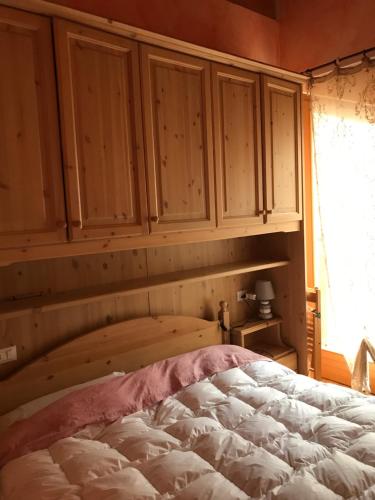 Residenza il bosco في Prada: غرفة نوم بها دواليب خشبية وسرير