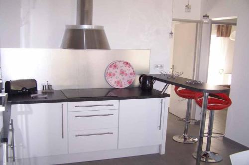 une cuisine avec des armoires blanches et un comptoir noir dans l'établissement CALYPSO 1731, aux Issambres