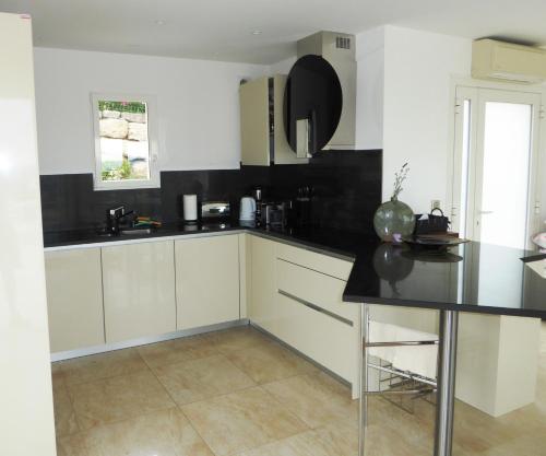 une cuisine avec des armoires blanches et un comptoir noir dans l'établissement HAGAY 1822, à Fréjus