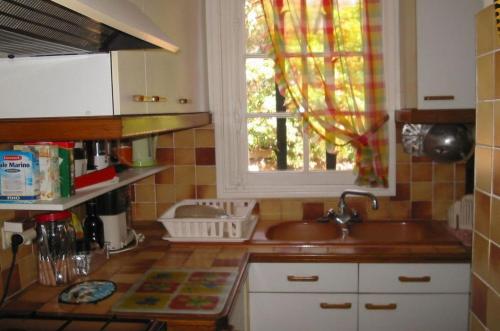 une cuisine avec un évier et une fenêtre dans l'établissement LE BIJOU 111, aux Issambres