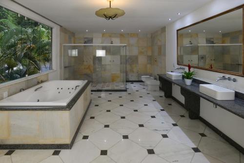 a bathroom with a tub and a toilet and a sink at Rio Boutique Suites in Rio de Janeiro