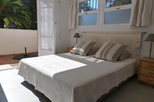 - une chambre avec un grand lit blanc et des fenêtres dans l'établissement LOU MAZETT 2465, aux Issambres