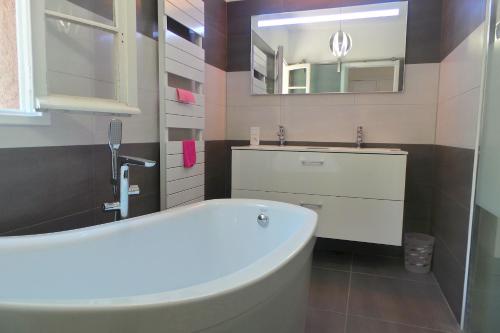 une salle de bain avec une baignoire, un lavabo et un miroir dans l'établissement PREGOT DIOU 202 villa, aux Issambres