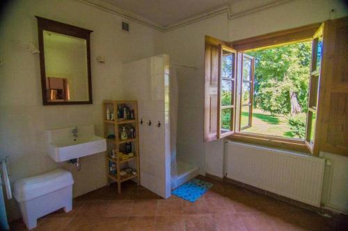 La salle de bains est pourvue d'un lavabo, d'un miroir et d'une fenêtre. dans l'établissement Świętokrzyskie Dworek Radkowice Kasztanowa Aleja, à Radkowice