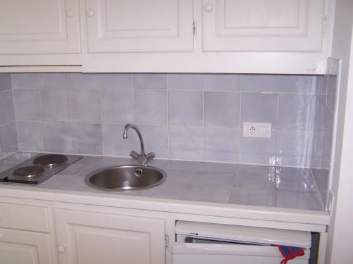 d'un comptoir de cuisine avec un évier et des placards blancs. dans l'établissement Villa Deux -141, à Sainte-Maxime