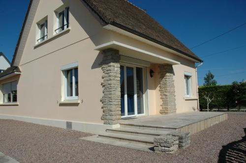 a small white house with a porch and stairs at Villa Magulie, le calme en bord de plage in Ver-sur-Mer