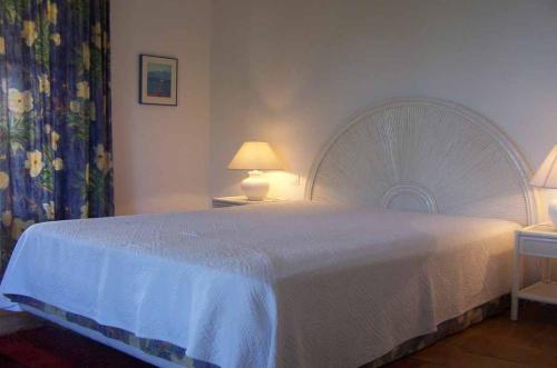 - une chambre avec un grand lit et un couvre-lit blanc dans l'établissement Villa Deux -141, à Sainte-Maxime