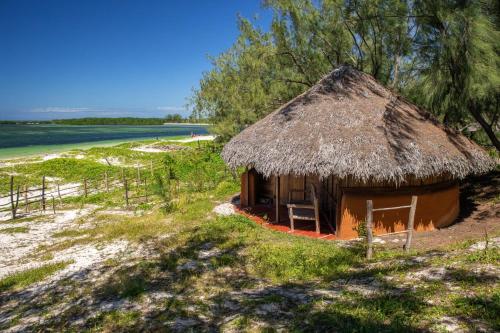 małą chatę z dachem krytym strzechą na plaży w obiekcie Varatraza Wind Riders w mieście Antsiranana