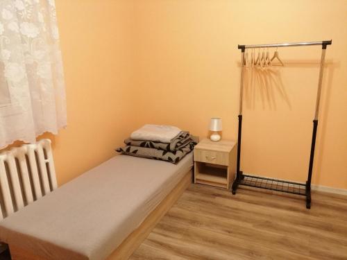 a small bedroom with a bed and a night stand at Apartament Reymonta in Łowicz