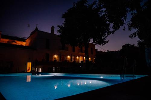 una piscina frente a un edificio por la noche en HOTEL LUZ ALMONASTER en Almonaster la Real