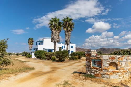 a house on a dirt road with palm trees at Surfer Paradise in Naxos Chora