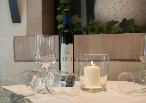 a bottle of wine sitting on a table with glasses at Jungfrau Hotel in Wilderswil