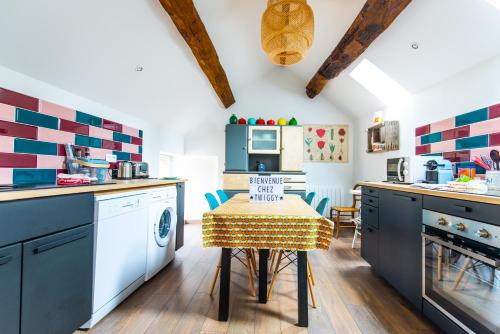 une cuisine avec des armoires bleues et une table avec un chiffon de table jaune dans l'établissement Chez Twiggy - Guesthouse vintage à Prenois, à Prenois