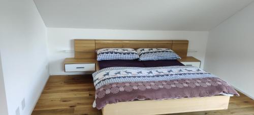 a bed with a wooden headboard in a bedroom at Schöne Wohnung in Walenstadt in Walenstadt