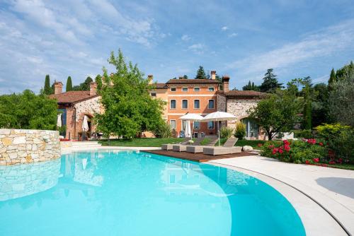 a large swimming pool in front of a house at Borghetto San Biagio Relais Agriturismo in Thiene