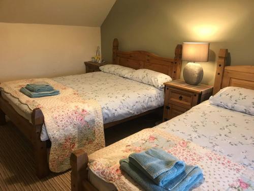 1 dormitorio con 2 camas y toallas. en 28 Hillside, en Lochinver