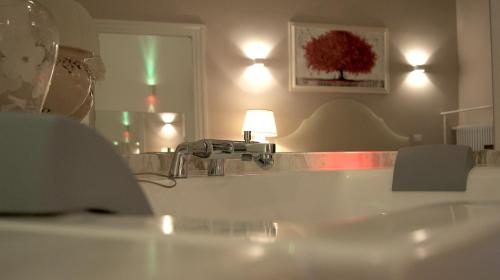 a bathroom with a sink and a lamp and a mirror at La Maison in Taranto