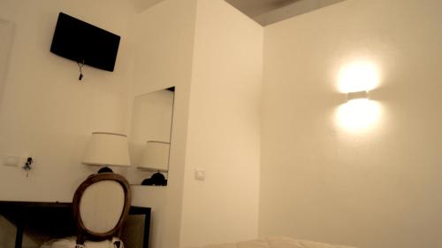 a room with a mirror and a lamp on a wall at La Maison in Taranto