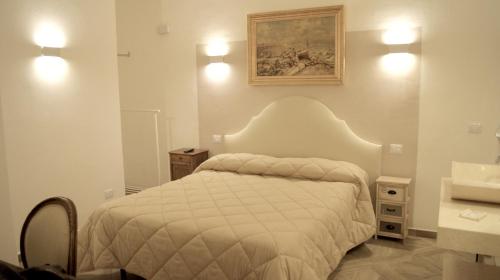 a bedroom with a white bed and a sink at La Maison in Taranto