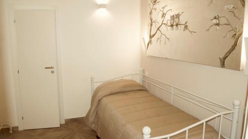 a bedroom with a bed and a painting on the wall at La Maison in Taranto