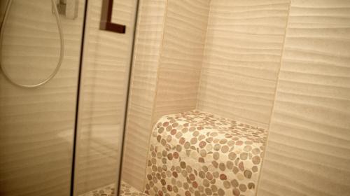 a shower with a chair in the corner of a room at La Maison in Taranto