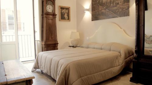 a bedroom with a bed with a clock on the wall at La Maison in Taranto