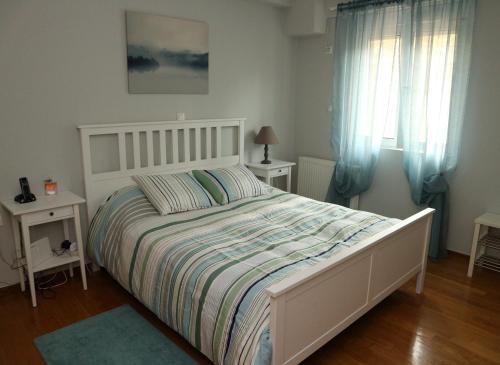 a bedroom with a white bed and two windows at Modern Riviera Azure Residence close to beach in Athens