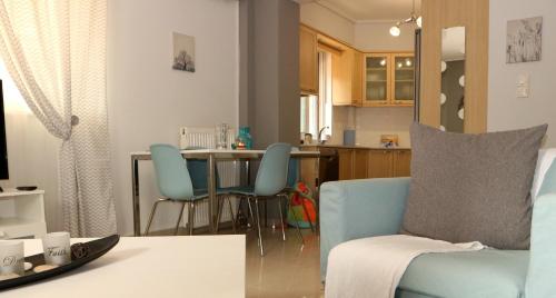a living room with a blue couch and a kitchen at Modern Riviera Azure Residence close to beach in Athens