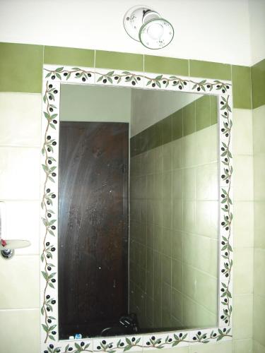 a mirror in a bathroom with a green tiled wall at Agriturismo La Scarpaia in Anghiari