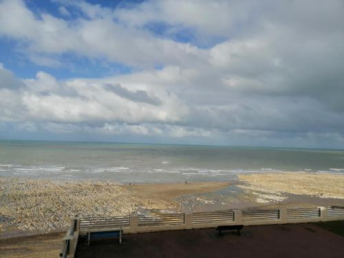 a view of a beach with a fence and the ocean at Le cabanon in Méneslies