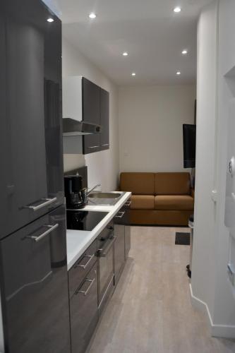 une cuisine avec un évier et un canapé dans une chambre dans l'établissement Petit T2 hypercentre avec terrasse privée - 006, à Rouen