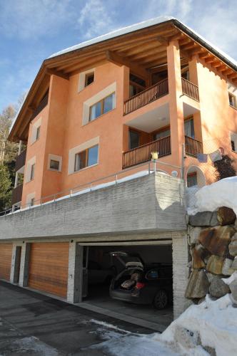 a building with a parking garage with a car in it at Chesa Chavriol in Pontresina