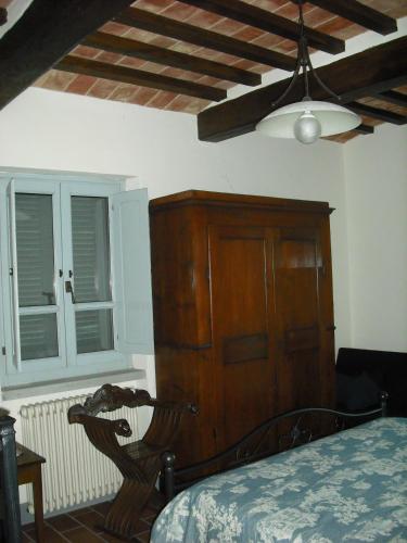a bedroom with a bed and a wooden cabinet at Agriturismo La Scarpaia in Anghiari