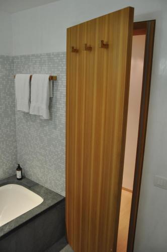 a bathroom with a wooden door next to a sink at Chesa Chavriol in Pontresina