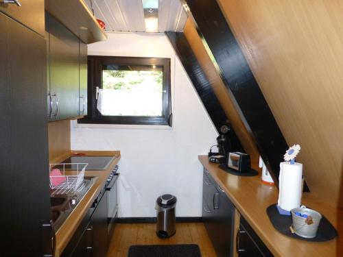 eine kleine Küche mit einer Theke und einem Fenster in der Unterkunft Ferienhaus Mauer Krombachtalsperre, exclusive Nebenkosten Strom in Driedorf