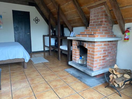 a brick fireplace in a room with a bed at Villa Calas in Vara Blanca
