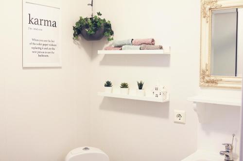 a bathroom with a toilet and some plants on the wall at Iðavellir Guesthouse in Skagaströnd