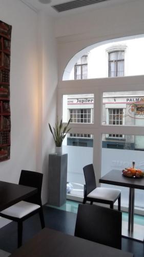 a dining room with a table and chairs and a window at Art de Sejour - B&B in Brussels