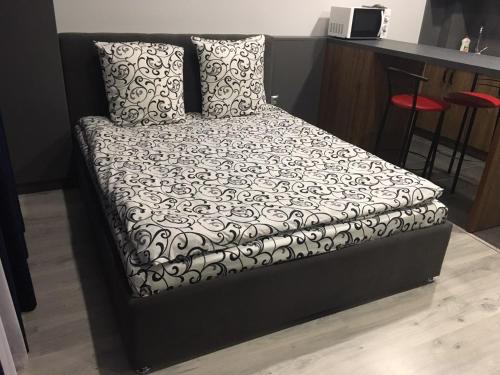 a bed with a black and white comforter and pillows at Centre in Uzhgorod in Uzhhorod