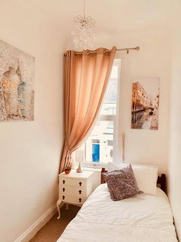 a bedroom with a bed and a window at Spacious two bedroom flat, central location in Plymouth