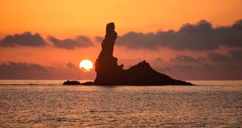 a rock formation in the ocean at sunset at Las Negras CENTRO. Al lado del mar. Con dos terrazas in Las Negras