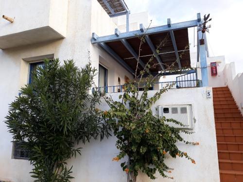 a building with a balcony and trees in front of it at Las Negras CENTRO. Al lado del mar. Con dos terrazas in Las Negras