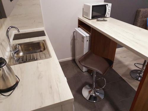 eine Küche mit einem Schreibtisch, einer Mikrowelle und einem Stuhl in der Unterkunft Apartservice in Uzhgorod s39 in Uschhorod