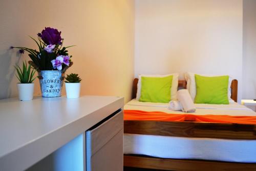 een kamer met twee bedden met groen en oranje bij Ria Guest House in Alvor