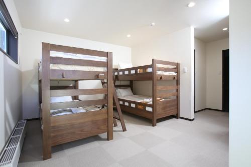 two bunk beds are in a room with at Snowlines Apartments Hakuba in Hakuba