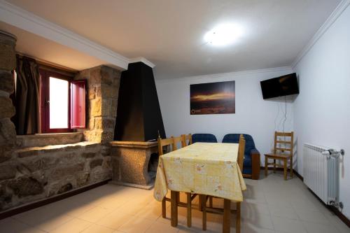a dining room with a table and a stone fireplace at Casas do Flor in Gouveia