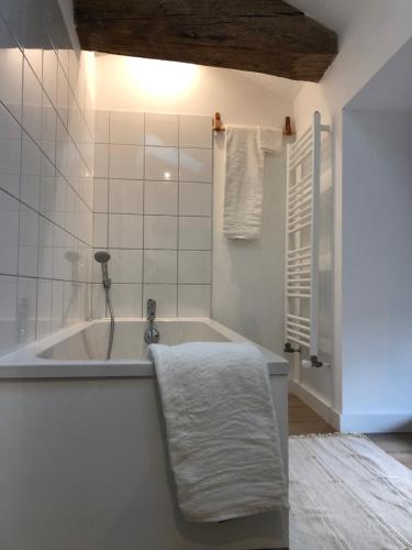 uma casa de banho com uma banheira e uma toalha em Gîte de la moinette em Azé