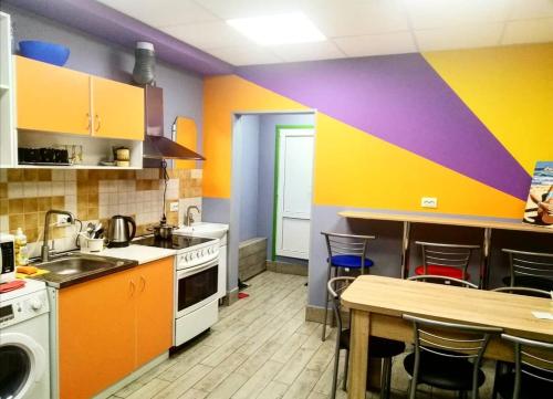 eine Küche mit farbenfrohen Wänden und einem Tisch mit Stühlen in der Unterkunft Hostel Meridian in Kiew