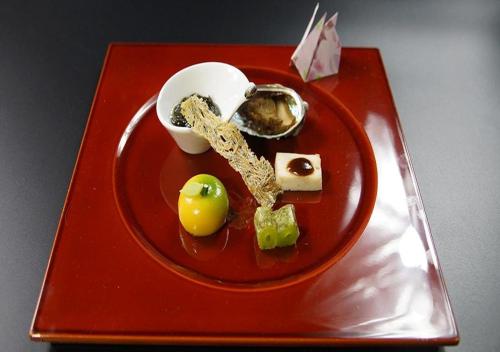 a red plate with food on a red tray at Hotel Asafuji in Fujikawaguchiko